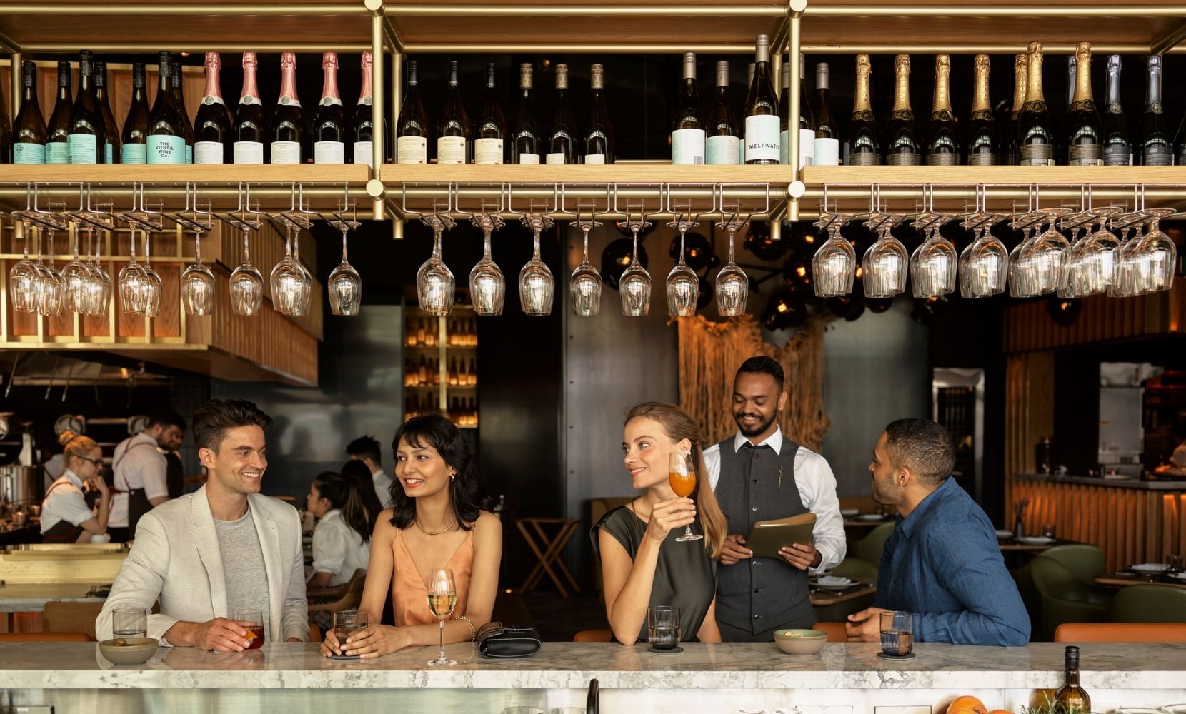 Customers at the Woodcut bar smiling and enjoying their drinks
